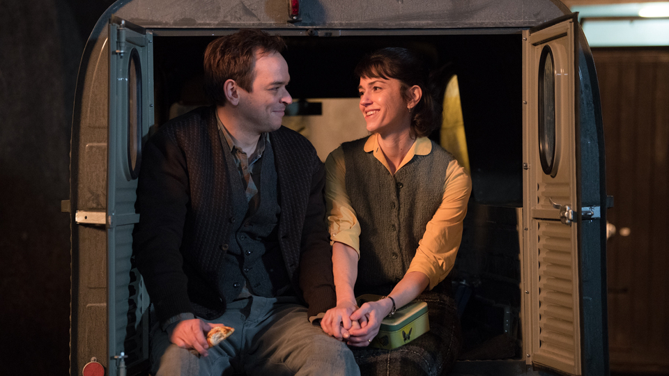 Als Emmi unverhofft ins Rampenlicht der Öffentlichkeit gerät, wird sie von ihrem Mann Ernst (Martin Vischer) unterstützt.